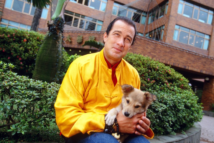 Action movie star Steven Seagal poses with a puppy in Taipei